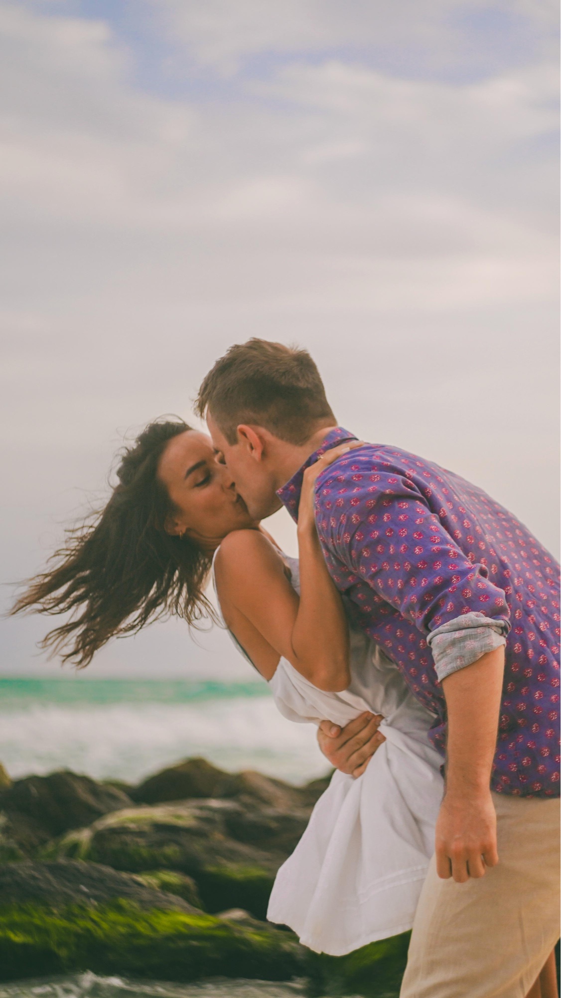 Couple kissing on the beach at sunset