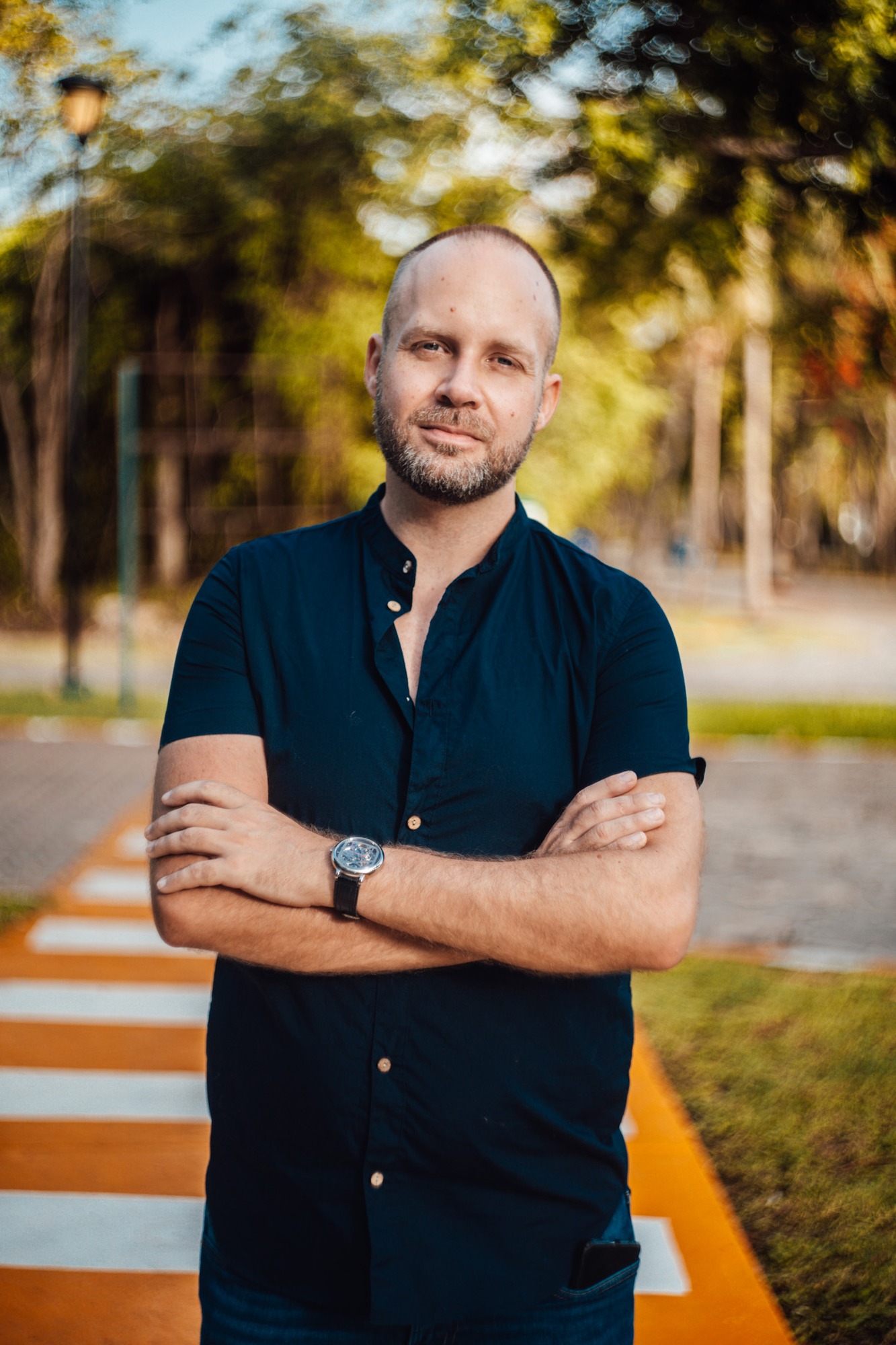 Brand portrait of a man in a dark shirt on a striped walkway